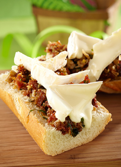 Crostini de queso Brie sobre pesto de tomate y berenjena