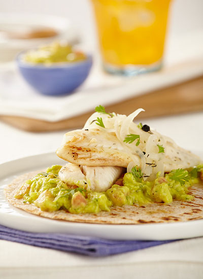 Tilapia sobre tortillinas con guacamole y cebolla en escabeche